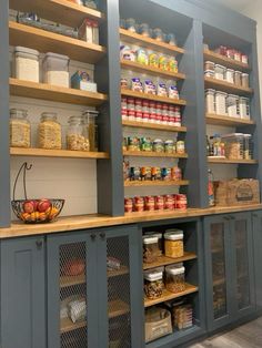 an organized pantry with lots of shelves and baskets on the top shelf, filled with food