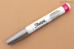 a pen that is sitting on top of a table next to a brown surface with the words shoppie written on it