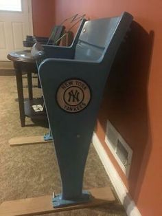 a large blue machine sitting on top of a hard wood floor next to a wall