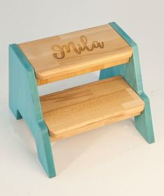 a small wooden step stool with the word smile on it's side and bottom shelf