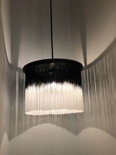 a black and white chandelier hanging from the ceiling in a room with walls