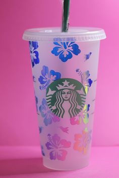 a starbucks cup with a straw sticking out of it's lid on a pink background