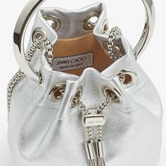 Silver Metallic Nappa Mini Bag | MICRO BON BON | Summer 2022 collection | JIMMY CHOO Luxury Bucket Bags For Party, Luxury Party Bucket Bag With Gold-tone Hardware, Luxury Bucket Bag For Party, Luxury Silver Bucket Bag For Party, Luxury Silver Leather Bucket Bag, Leather Shoulder Bag With Branded Hardware For Party, Luxury Silver Bucket Bag For Evening, Party Leather Shoulder Bag With Branded Hardware, Luxury Party Clutch Bucket Bag