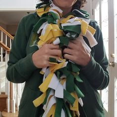 a woman wearing a green jacket and yellow ribbon around her neck