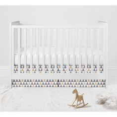 a white crib with a rocking horse next to it and a rug on the floor