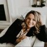 a woman laying on top of a white couch