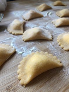 some dumplings are sitting on a wooden cutting board and ready to be made into pie crusts