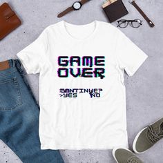 This nostalgic game over design is a great retro design or a great gift for the old school gamer in your life! This t-shirt is everything you've dreamed of and more. It feels soft and lightweight, with the right amount of stretch. It's comfortable and flattering for all.  * 100% combed and ring-spun cotton (Heather colors contain polyester) * Ash color is 99% combed and ring-spun cotton, 1% polyester * Heather colors are 52% combed and ring-spun cotton, 48% polyester * Athletic and Black Heather are 90% combed and ring-spun cotton, 10% polyester * Heather Prism colors are 99% combed and ring-spun cotton, 1% polyester * Fabric weight: 4.2 oz (142 g/m2) * Pre-shrunk fabric * Side-seamed construction * Shoulder-to-shoulder taping Gaming Event Crew Neck T-shirt With Letter Print, Gamer Tops With Letter Print, Cotton T-shirt With Letter Print For Gaming Events, Casual Tops With Letter Print For Gaming Events, Casual Top With Letter Print For Gaming Events, Casual Letter Print Top For Gaming Events, Gamer Style White Top For Streetwear, White Cotton Gamer T-shirt, Crew Neck T-shirt For Gaming Events With Letter Print