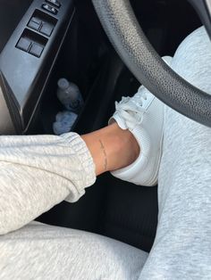 a person with their foot on the steering wheel of a car