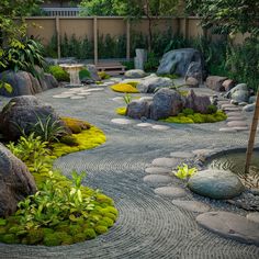 a japanese garden with rocks and moss growing on the ground, surrounded by trees and bushes