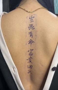 the back of a woman's neck with chinese writing on her upper arm and lower back