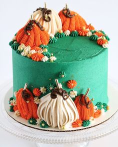 there is a green cake decorated with pumpkins