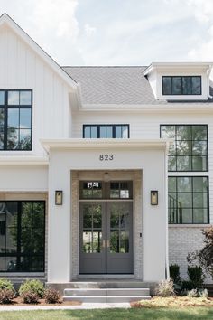 a large white house with black windows and doors