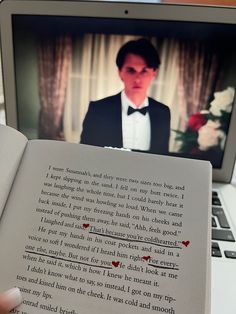 someone is holding an open book in front of a laptop screen with the image of a man wearing a tuxedo