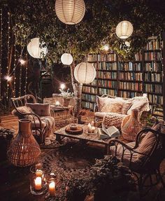 a living room filled with lots of furniture and bookshelves covered in lights at night