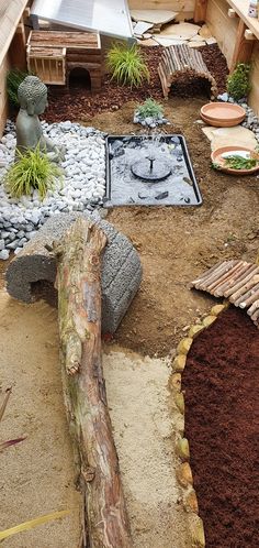 a wooden bench sitting next to a garden filled with plants and rocks on top of dirt