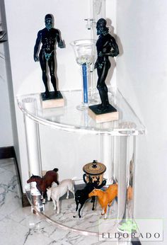 a glass shelf with figurines on top of it