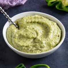 a white bowl filled with green pesto sauce