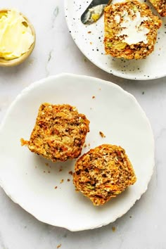 two pieces of carrot muffins on a white plate next to a fork and spoon