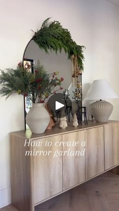 a mirror sitting on top of a wooden dresser next to a vase filled with flowers