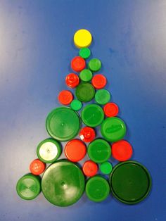 a christmas tree made out of green and orange buttons on a blue surface with white background