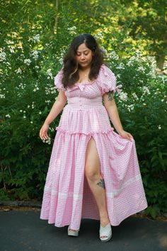 Our Sweet Strawberry Goddess is made with love and grace, and sweetens up the space. Made from lightweight seersucker cotton, it’s perfect for summer days! Featuring puff sleeves sprinkled with daisies, a flattering bodice, pockets and a ruffled bust - this summer twist on our classic Goddess Gown is a must have! Model wearing size M. Skirt length 41 inches on all sizes. Spring Prairie Dress With Smocked Bodice And Short Sleeves, Spring Short Sleeve Prairie Dress With Smocked Bodice, Short Sleeve Prairie Dress For Spring Garden Party, Short Sleeve Prairie Dress With Ruffles For Garden Party, Summer Garden Party Prairie Dress With Ruffle Hem, Spring Prairie Dress With Ruffles And Short Sleeves, Summer Short Sleeve Prairie Dress With Ruffles, Summer Prairie Dress With Puff Sleeves For Garden Party, Summer Prairie Dress With Puff Sleeves And Ruffles