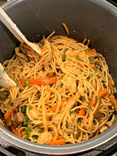 a pot filled with noodles and vegetables on top of a stove