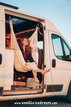 a woman sitting in a hammock on the back of a van