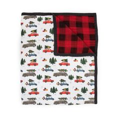 a red and black plaid blanket with cars, trees and trucks on it in the snow