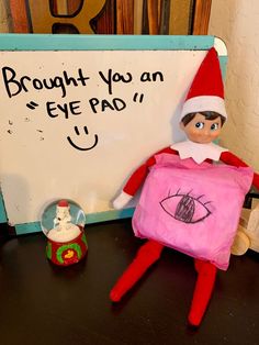 an elf is sitting next to a sign that says, brought you an eye pad