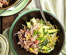 a bowl filled with meat and veggies on top of a table next to a glass of water