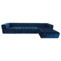 a blue velvet sectional sofa with rounded back and foot rests on an isolated white background