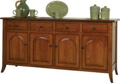 the sideboard is made out of wood and has two green vases on top