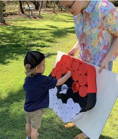 a little boy is playing with a giant piece of art