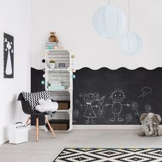 a child's room with chalkboard walls and toys on the floor in front of it