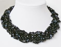 This 9 strand braided beauty is strung with a variety of unique black beads! Sparkling gunmetal black crystals are weaved with jet black crystals, seed beads and pearls, and finished off with a touch of colorful aurora borealis crystals for a one-of-a-kind statement piece!  This necklace goes great with everyday sweaters, business attire, and of course- your favorite cocktail dress!  It hangs luxuriously across the collarbone for a super classy look!  Need matching earrings or bracelets? No problem! Just drop me a message!  Measurements: Approximately 17 inches long with a 3 inch chain extender for easy length adjustment. Please message me for further length adjustments.  Each piece of jewelry from my shop comes beautifully packaged and ready for gift giving.  Thank you for visiting my sho Black Crystal Necklace, Black Necklace Statement, Crystal Statement Necklace, Strand Braid, Lapis Lazuli Necklace, Necklace Pearl, Chain Extenders, Statement Necklaces, Necklace Black