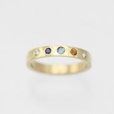 A colorful way to wear your family's birthstones! This ring is hand fabricated in solid 14ky gold and customized to use any number and combination of birthstones. The hammered texture gives the gold an extra glimmer! The ring is 3mm wide and 1.5mm thick. The stones are arranged in a straight line. Choose your ring size and desired number of birthstones when adding this item to your cart. Also, note the birthstone order from left to right in the text box. Please allow up to 14 business days for fabrication. Looks great stacked!!  Comes with a lifetime warranty, polishing cloth, and a gift box. All stones are synthetic except for Garnet, Amethyst, Peridot and Citrine which are natural. Feel free to ask for a price quote with all natural stones. Also available in sterling silver: https://www. Gold Multi-stone Birthstone Ring For Anniversary, Recycled Gold Birthstone Ring For Promise, Promise Ring With Birthstone In Recycled Gold, 14k Yellow Gold Multi-stone Birthstone Ring, Multi-stone 14k Yellow Gold Birthstone Ring, Multi-stone Yellow Gold Birthstone Ring In 14k, Yellow Gold Multi-stone Birthstone Ring In 14k Gold, Yellow Gold Birthstone Ring In Recycled Gold, Yellow Gold Birthstone Ring With Recycled Gold