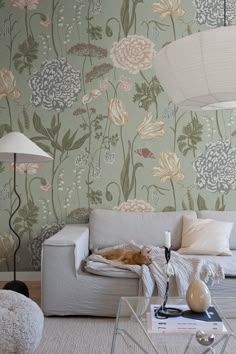 a living room filled with furniture and wallpaper covered in floral design on the walls