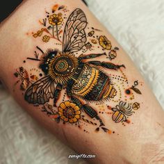 a bee tattoo on the leg with flowers and bees around it's legs,