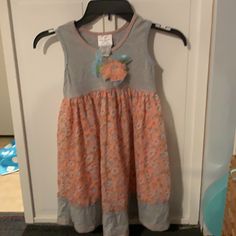 Adorable Little Girl Dress Size 6. Gray Top And Bottom With A Peach Stitching Around The Neck And Hem Line. Peach Background With Blue And White Flowers With Green Leaves. Pretty Peach Flower Attached To The Front Chest With Sparkly Center. Never Worn. Playful Orange Sleeveless Dress, Orange Sleeveless Dress For Playtime, Casual Orange Playtime Dress, Casual Orange Dresses For Playtime, Casual Orange Dress For Playtime, Playful Orange Cotton Dress, Playful Orange Dress For Spring, Playful Orange Spring Dress, Orange Cotton Playtime Dress