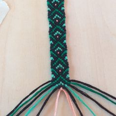 a close up of a piece of beaded material on a wooden table with scissors