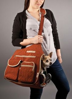 a woman holding a purse with a dog inside it