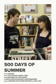 a man and woman standing next to each other in front of a bookshelf