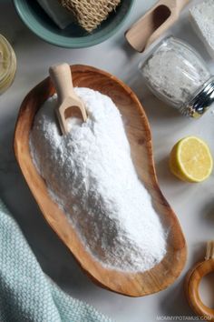 a wooden bowl filled with white powder next to other ingredients and utensils on a table