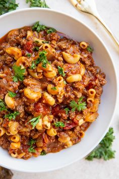 a white bowl filled with pasta and meat