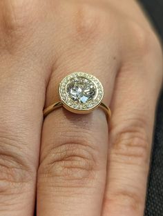 a close up of a person's hand with a diamond ring on their finger