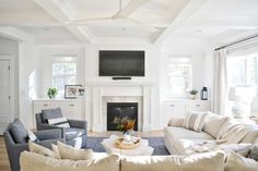 a living room filled with furniture and a flat screen tv mounted on the wall above a fireplace