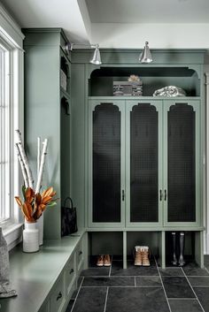 a walk in closet filled with lots of green cabinets