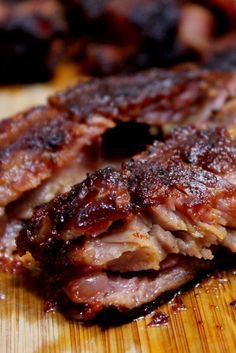 two pieces of meat sitting on top of a wooden cutting board