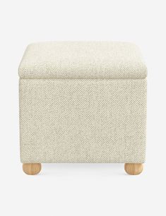 an upholstered footstool with wooden legs and a white fabric cover on the top